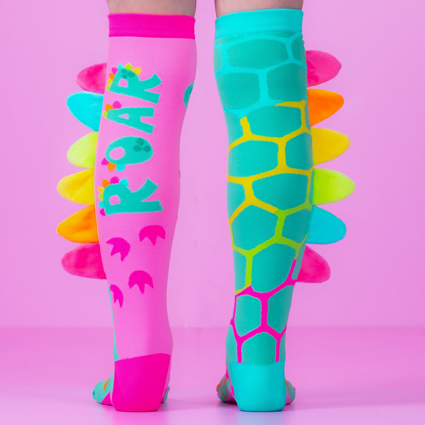 Colorful dinosaur knee high socks for kids and adults with vibrant patterns and plush spikes design.
