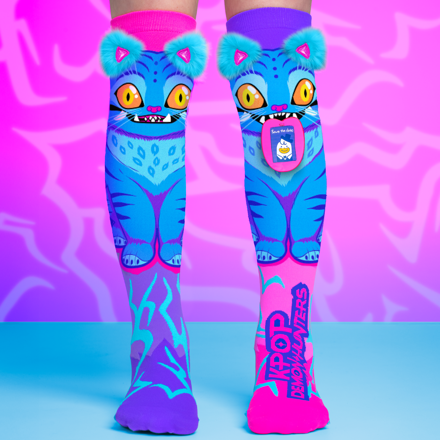 Colorful KPop Demon Hunters Derpy knee high socks featuring blue monster character artwork and plush fuzzy ear details.