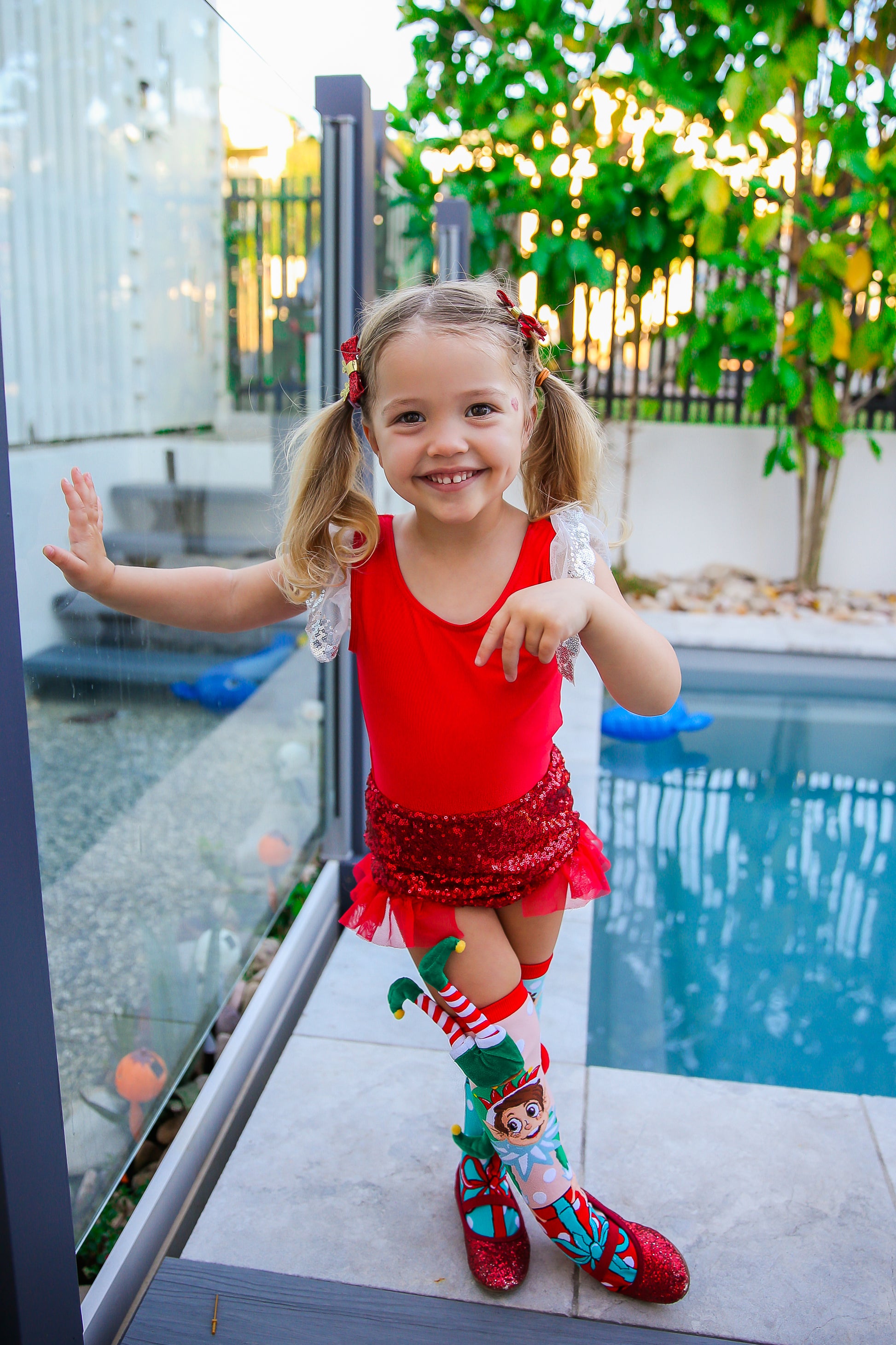 Christmas novelty socks featuring attached plush elf characters and bright festive colors