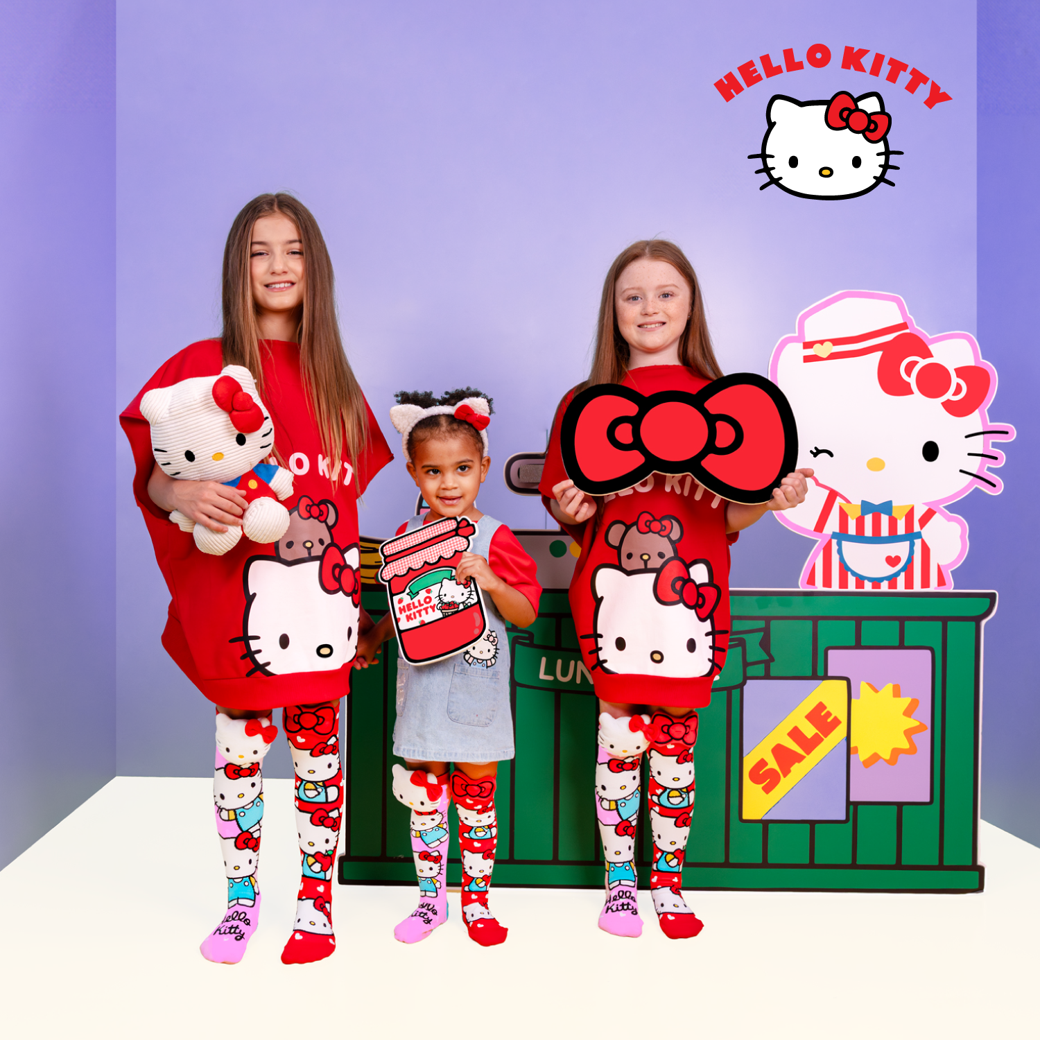 Girls wearing Hello Kitty knee high socks with colorful character graphics and plush bows