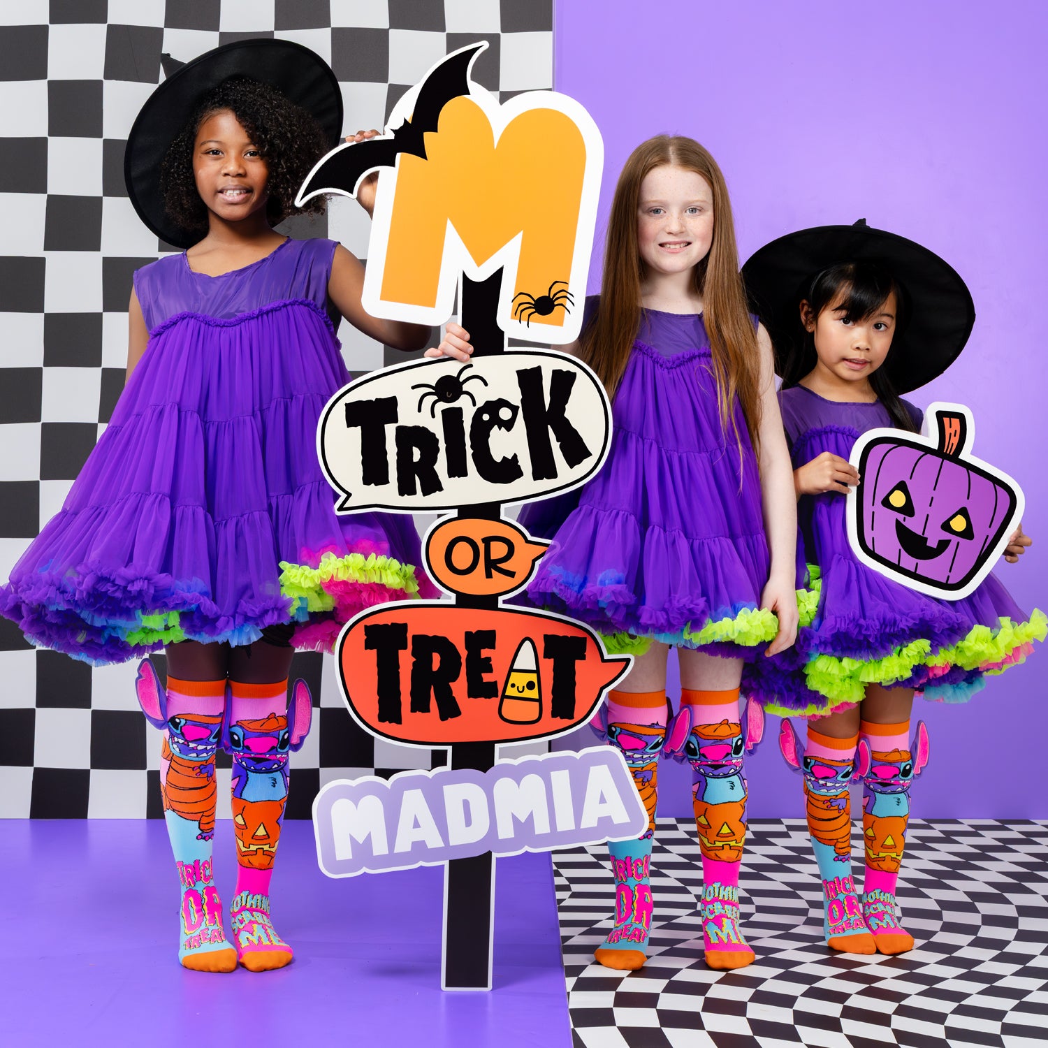 Kids wearing Disney Stitch neon Halloween knee high socks with pumpkin graphics, trick or treat text, and colorful witch costumes.