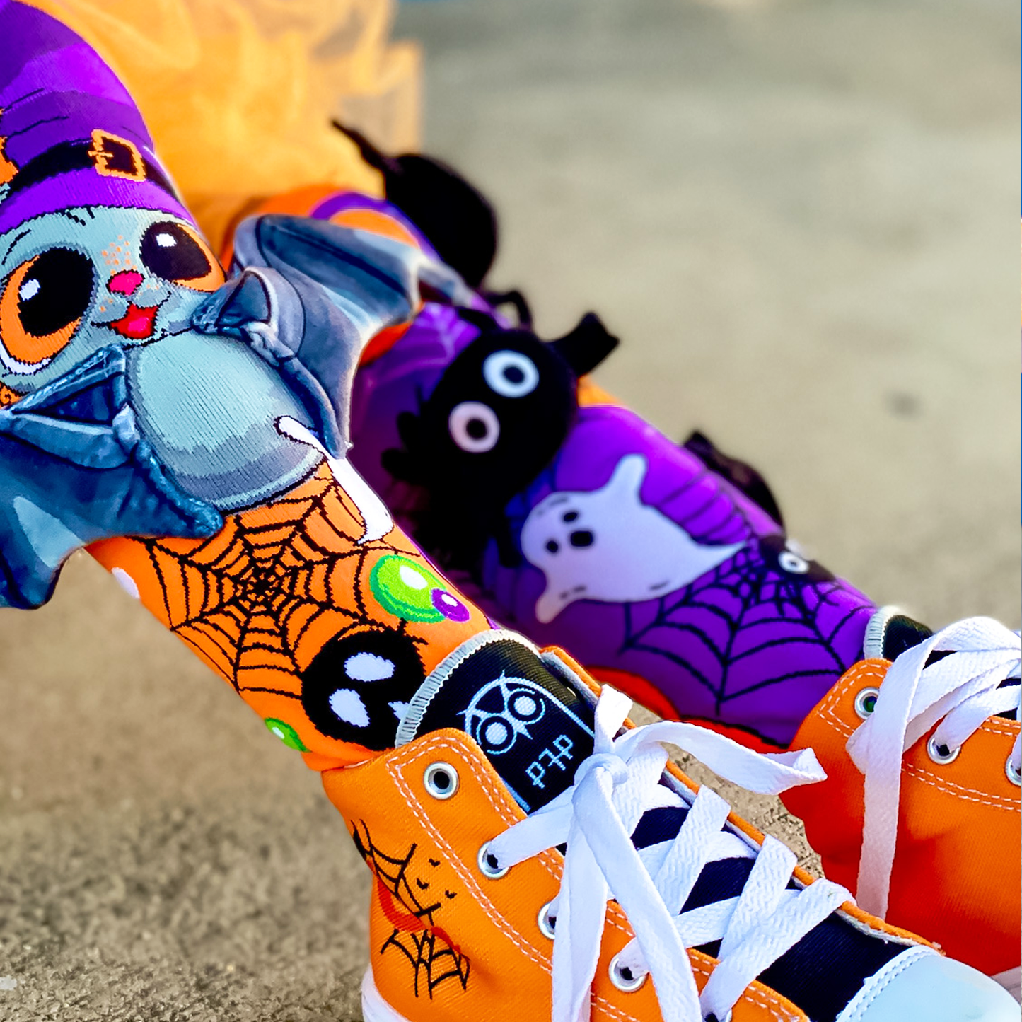 Fun Halloween knee high socks with spooky plush spiders and bat wing details for trick-or-treat fun.
