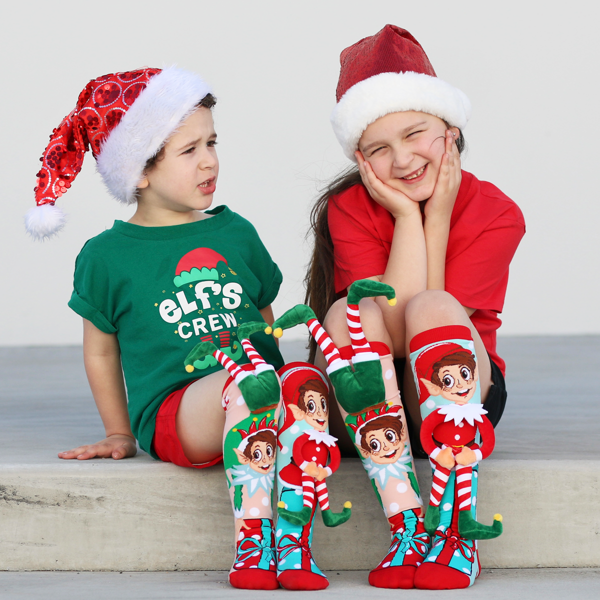 Holiday elf novelty socks with attached plush elf details and bright Christmas colors.