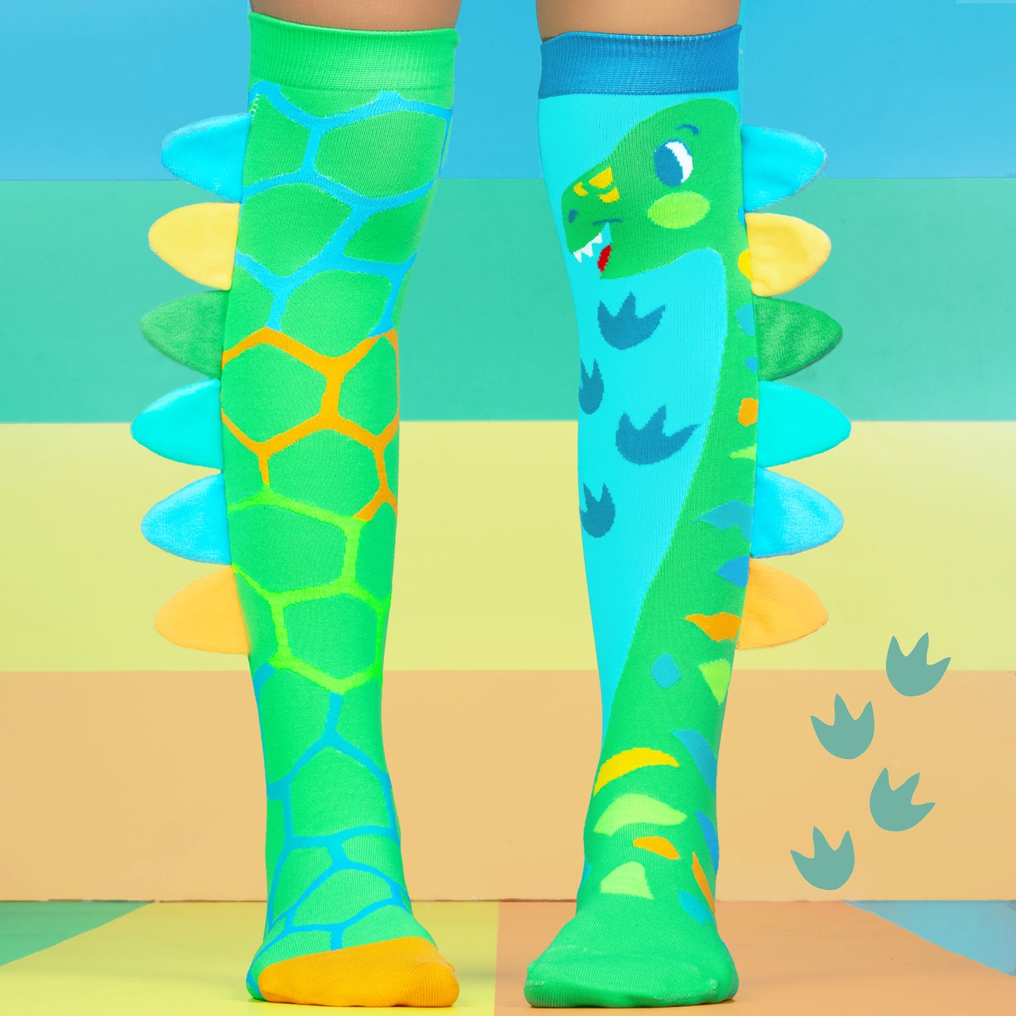 Kids dinosaur socks in green and blue with playful cartoon dinosaur graphics