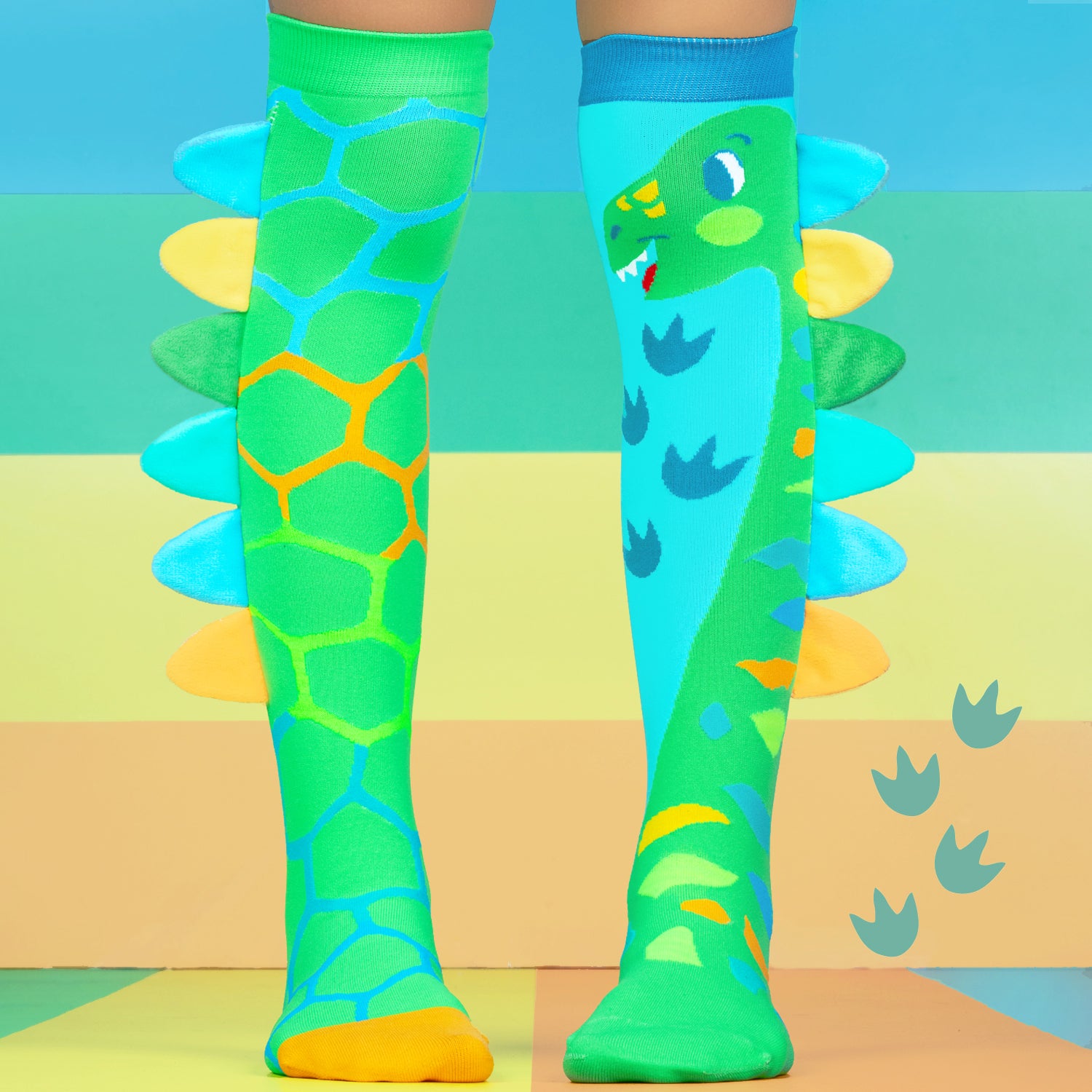Kids dinosaur socks in green and blue with playful cartoon dinosaur graphics