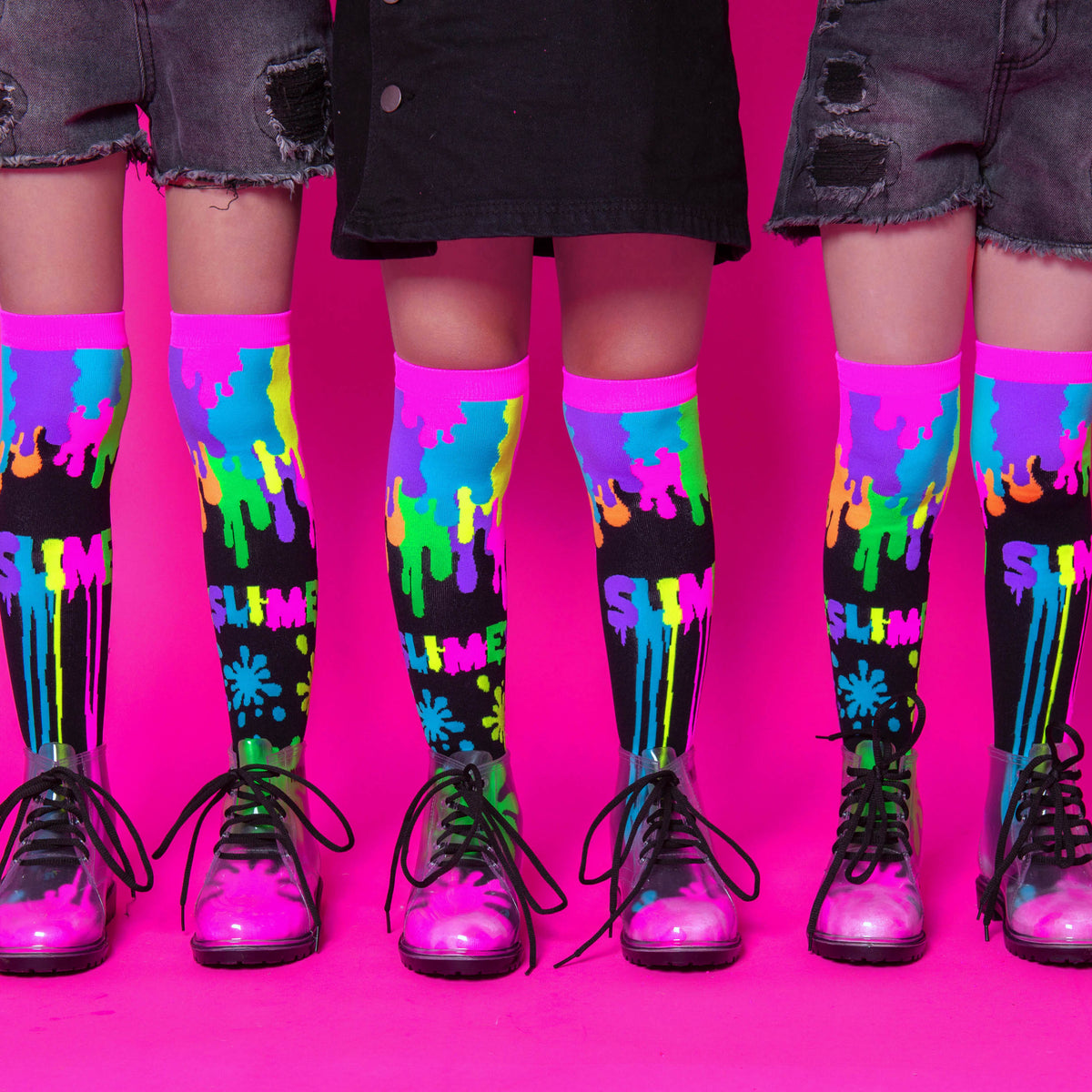 Bright neon MADMIA slime socks with colorful gooey patterns glowing under UV light for fun party outfits.