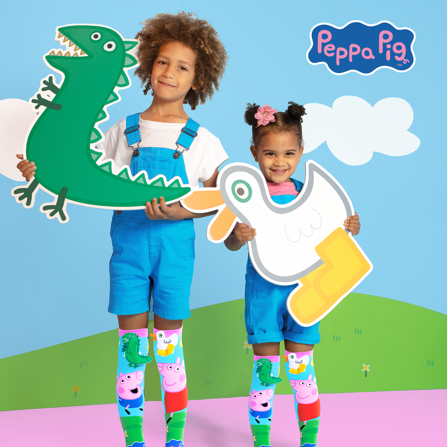 Children wearing colorful Peppa Pig knee high socks with dinosaur and duck plush details