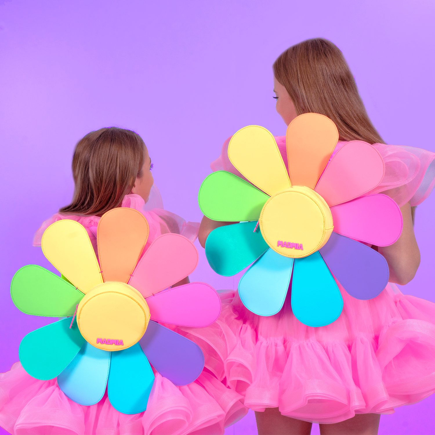 Girls wearing cute daisy shaped backpacks in bright rainbow colors