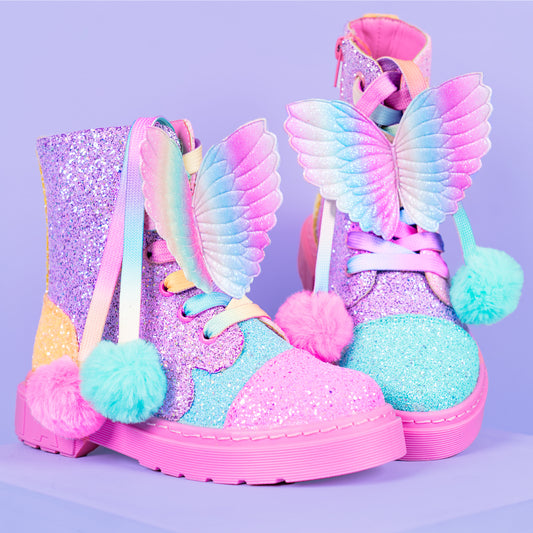 Rainbow glitter boots for kids and adults featuring colorful butterfly wings and pom pom lace details.