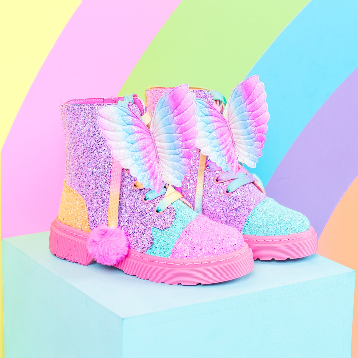 Sparkly rainbow boots with colorful butterfly wings and soft pom pom lace details.