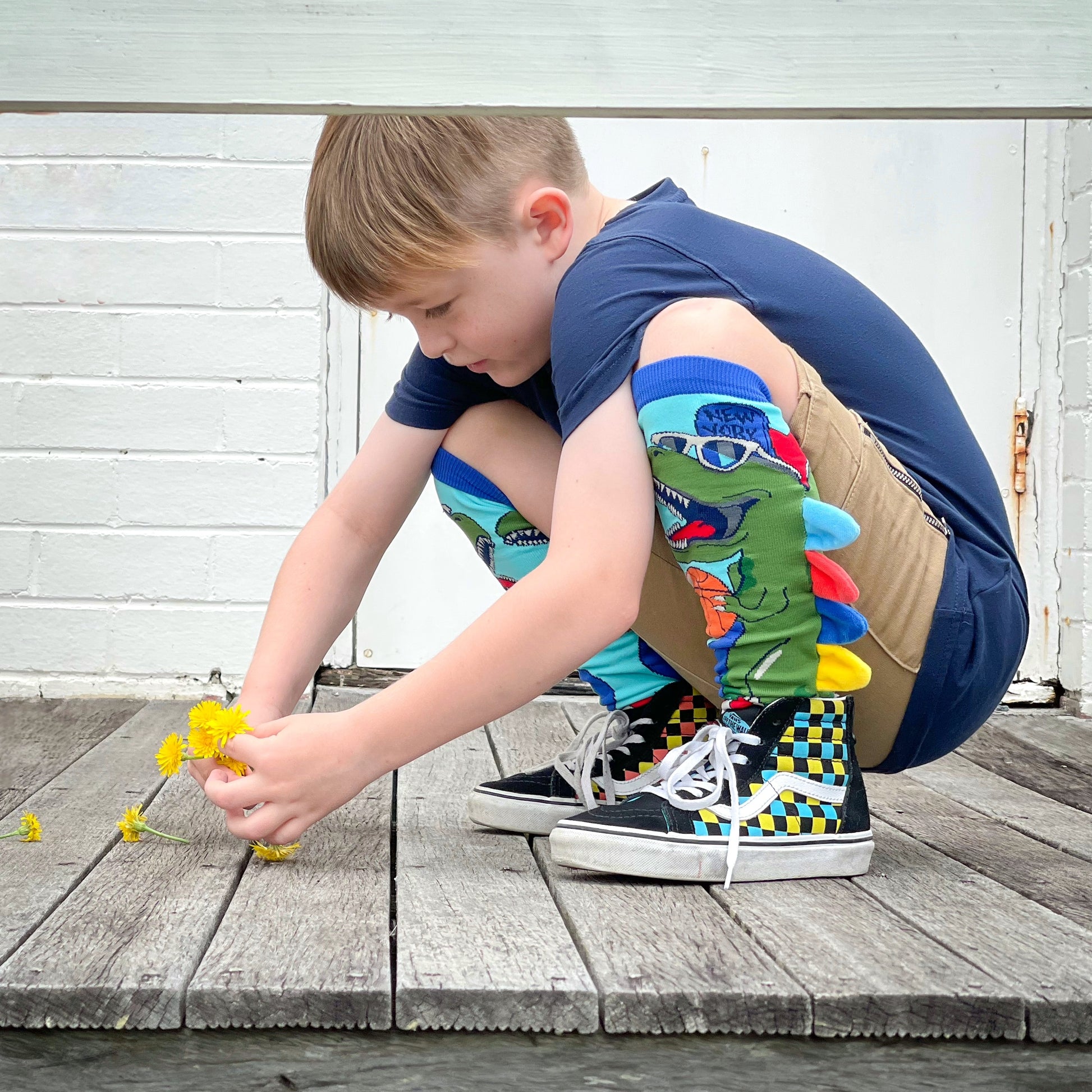 Colorful dinosaur socks featuring fun dino graphics and soft plush spike details.