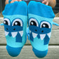 Fun shark knee high socks with colorful sea-inspired graphics and playful plush fins.