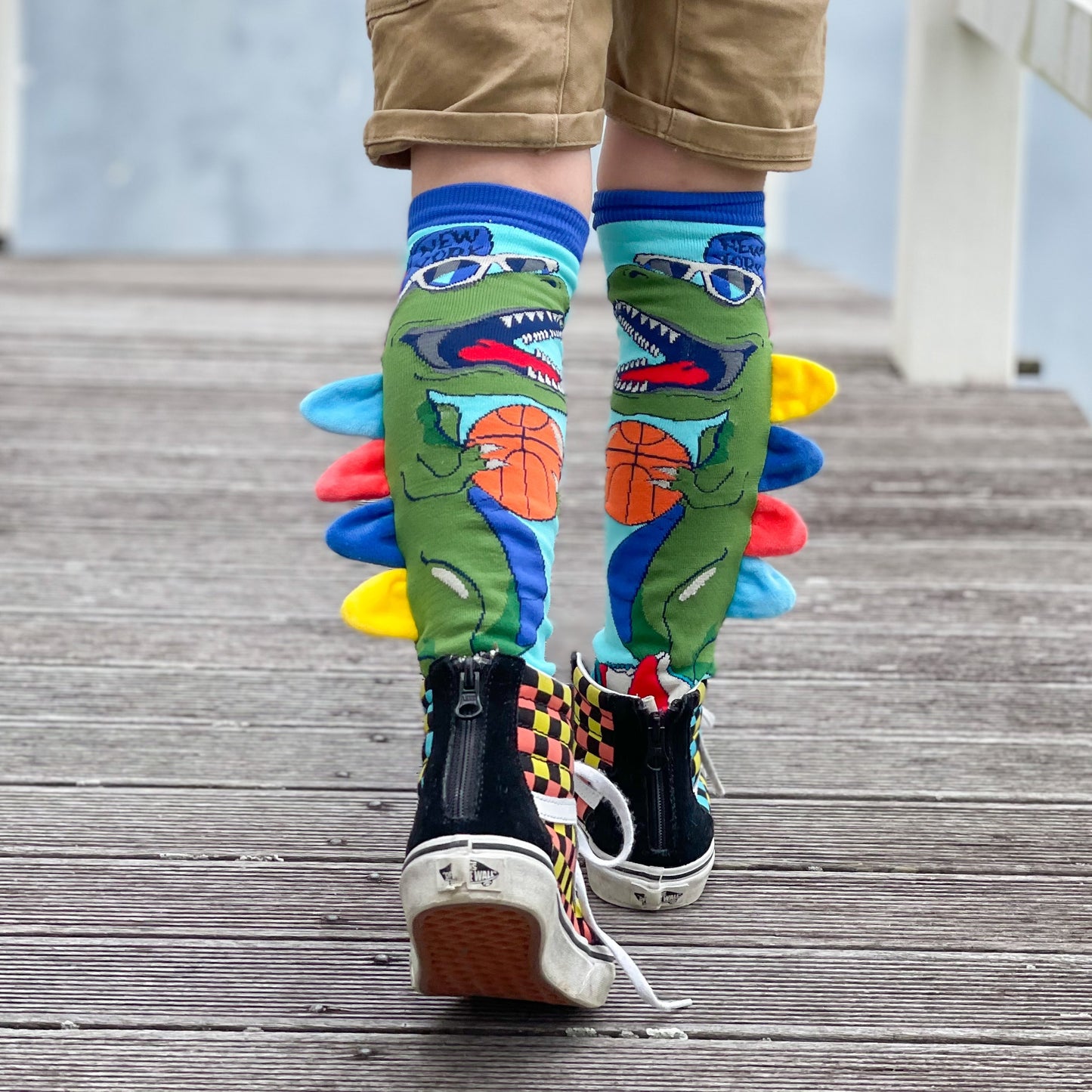 Kids dinosaur socks with colorful Jurassic-inspired patterns and plush spikes.