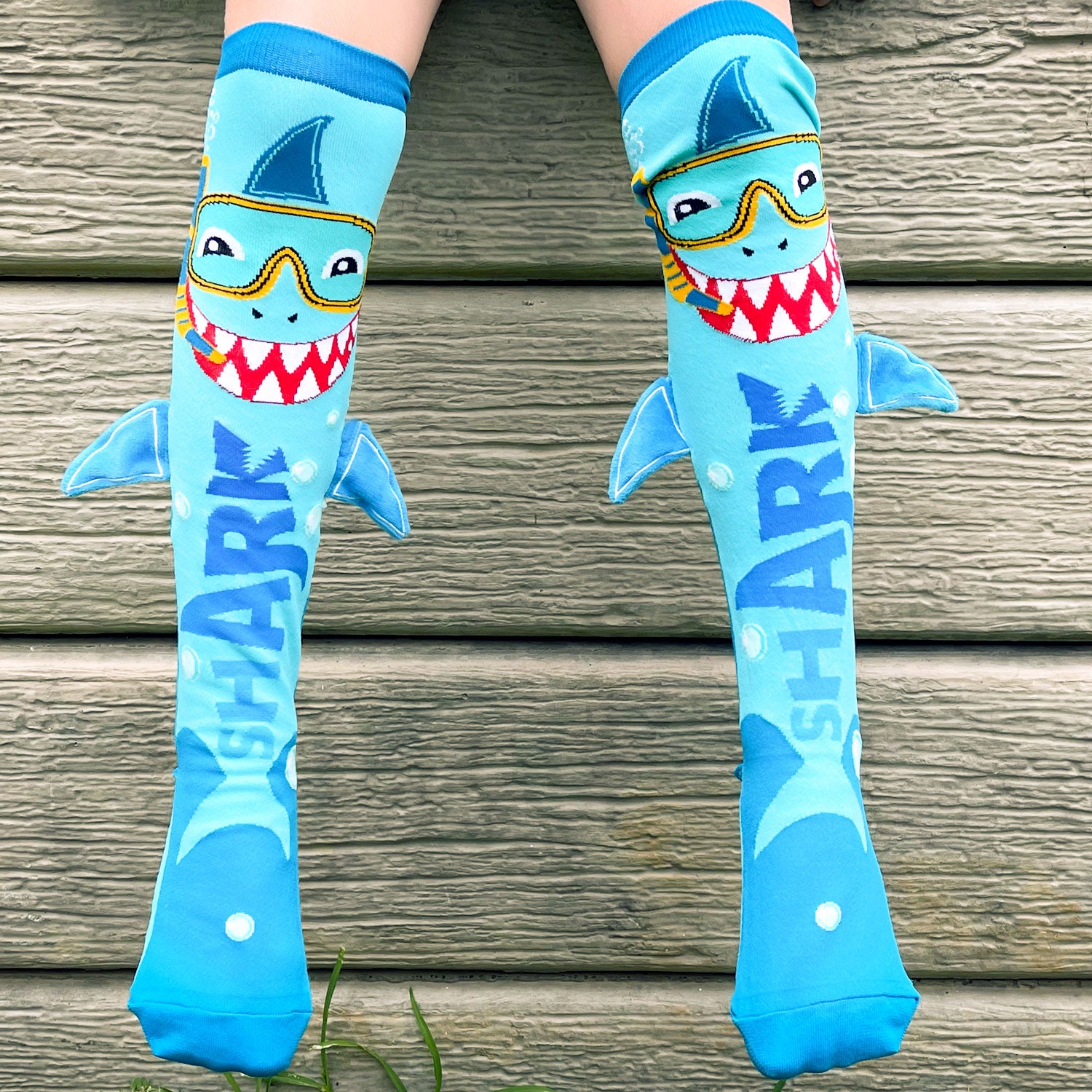 Ocean adventure shark socks featuring bright colors and attached plush fin details.