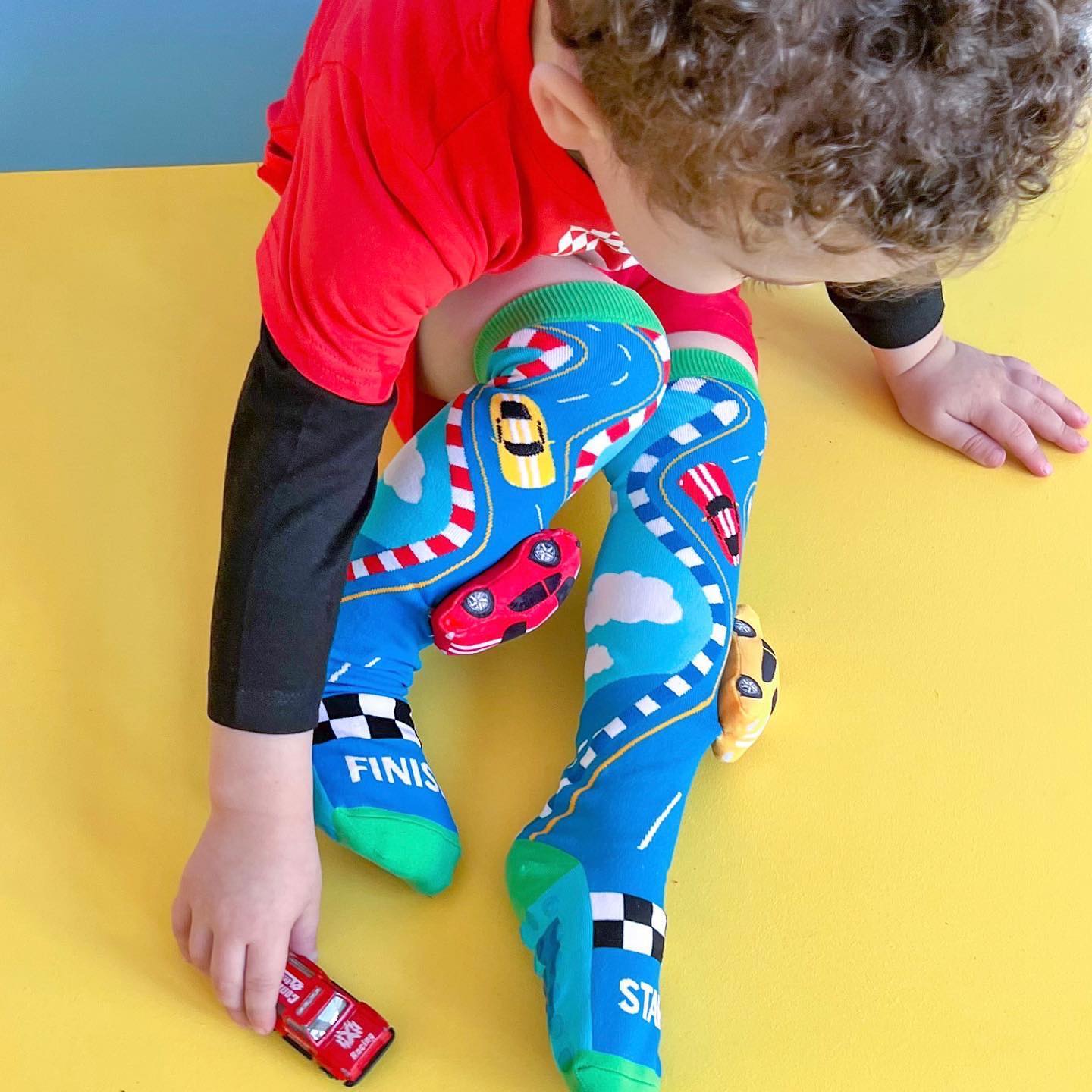 Race car novelty socks with bold colors and fun racing-themed patterns.